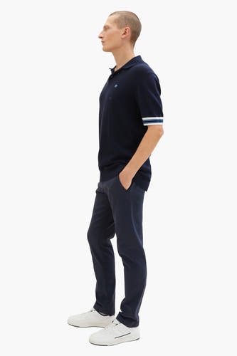 Jean bleu de TOM TAILOR, associé à un poloshirt bleu marine et des baskets blanches, en vue latérale.
