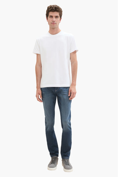 Donkerblauwe slim fit jeans van TOM TAILOR, gedragen met wit T-shirt en grijze sneakers, front view