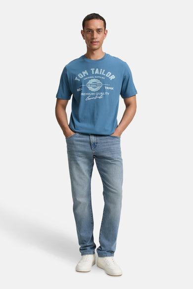 Blauw T-shirt met korte mouwen van TOM TAILOR, met opdruk, gecombineerd met jeans en witte schoenen.
