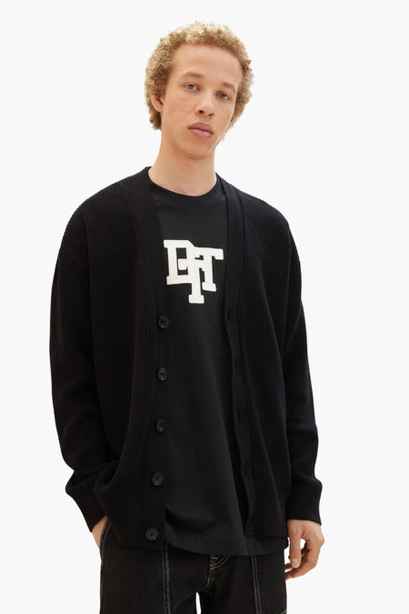 Gilet noir de TOM TAILOR avec fermeture à boutons sur un T-shirt noir avec une impression blanche.