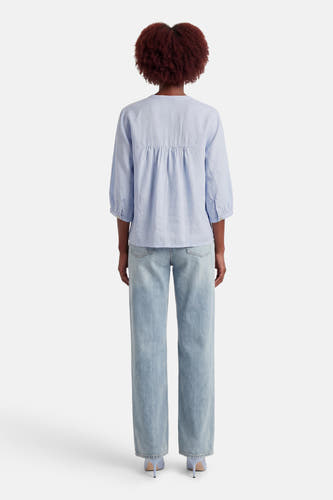 Chemise bleue à manches longues OPUS, associée à un jean ample et des talons bleus, vue de dos.