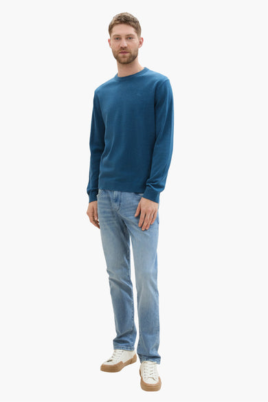 Blauwe trui met ronde hals van TOM TAILOR, gecombineerd met lichte jeans en crèmekleurige schoenen.