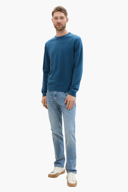 Blauwe trui met ronde hals van TOM TAILOR, gecombineerd met lichte jeans en crèmekleurige schoenen.