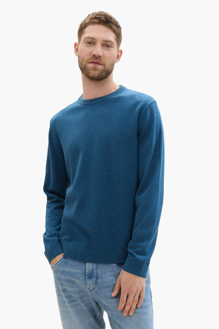 Blauwe trui met ronde hals van TOM TAILOR, gedragen met een lichte jeansbroek.
