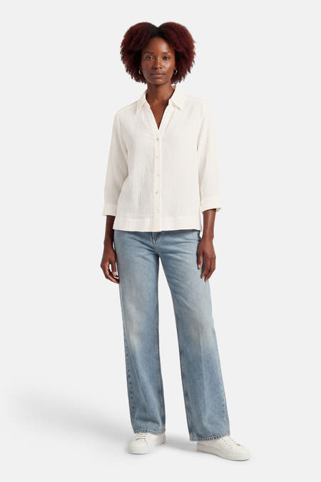 Wit overhemd met lange mouwen van OPUS, met een getextureerde stof en gedragen met jeans en witte sneakers.
