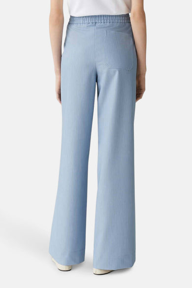 Blauwe broek van OPUS, met wijde pijpen en een elastische tailleband, gezien van achteren.