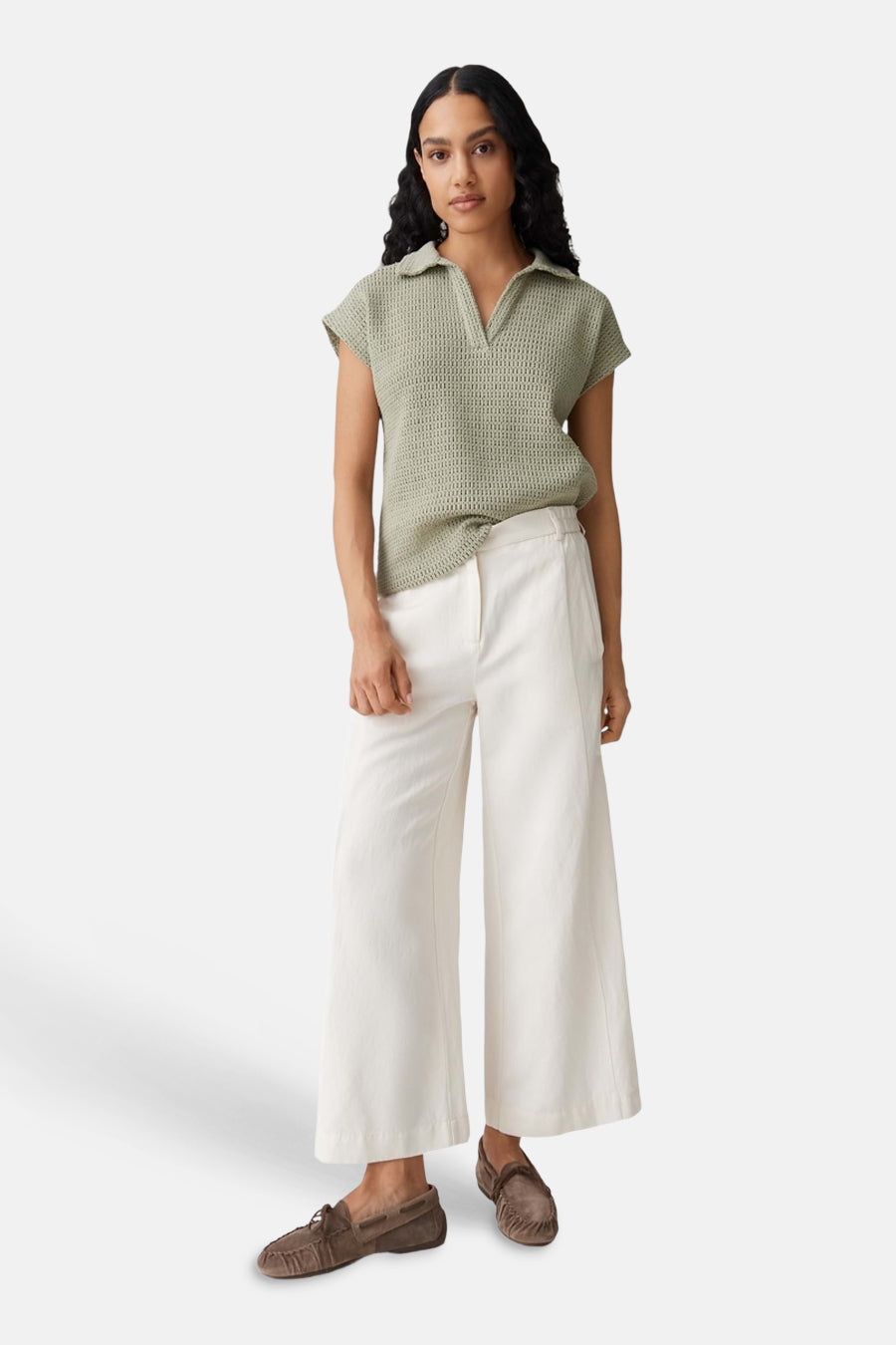 Groene polo met korte mouwen van OPUS, met open breisel en kraag, gedragen met witte broek en bruine loafers.