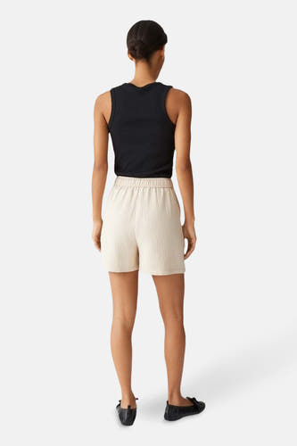 Beige court d'OPUS, vu de derrière, avec une ceinture élastique et une subtile texture.