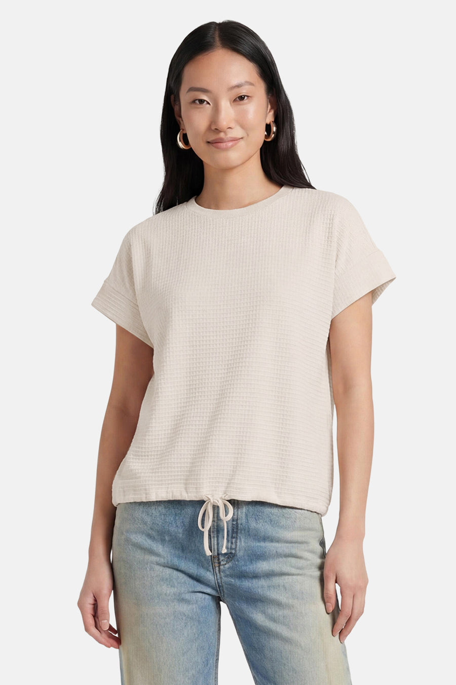 Beige korte mouwen T-shirt van OPUS met wafeltextuur en ronde hals, gedragen met blauwe jeans en gouden oorbellen, front view.