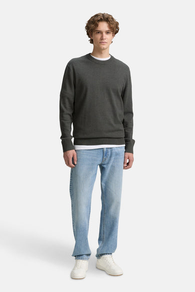 Groene trui met ronde hals van TOM TAILOR, gedragen over een wit shirt met lichtblauwe jeans en witte sneakers.
