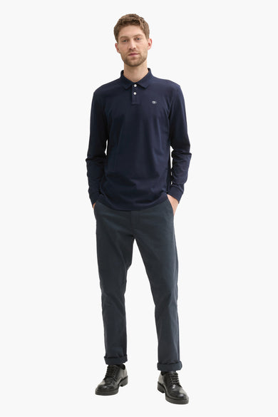 Polo bleu à longues manches de TOM TAILOR, porté avec un pantalon foncé et des chaussures noires.