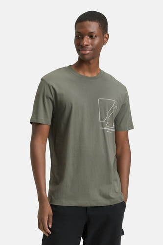 T-shirt vert de mantes courtes man TOM TOM TOMOR, im un graphique, associé à une pantalon noir et des baskets blanches.