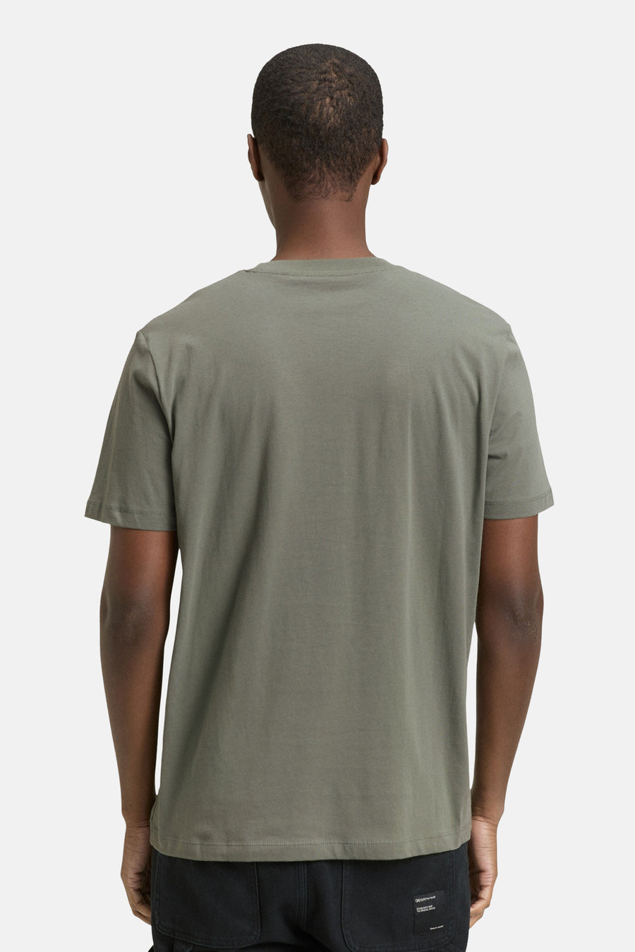 T-shirt vert de mantes courtes TOM TOMOROR, vu vu l'arrière, porté avec un pantalon noir.
