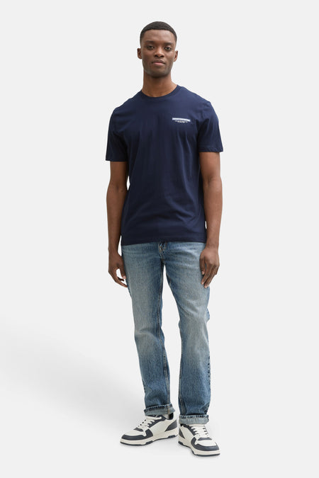Blauw T-shirt met korte mouwen van TOM TAILOR, met een kleine tekstprint, gecombineerd met blauwe jeans en witte sneakers.
