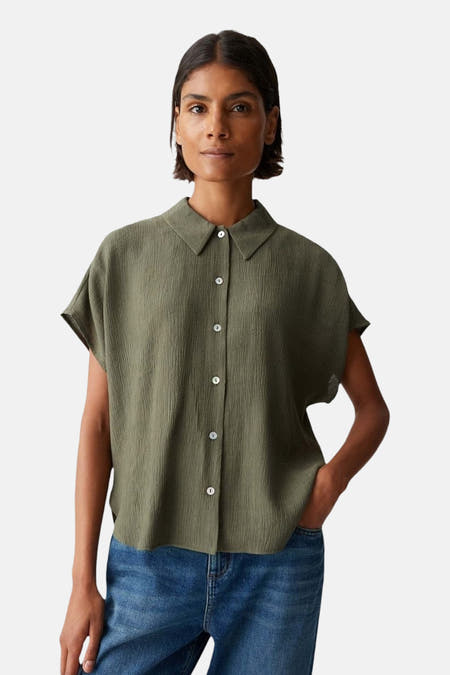 Chemise verte à manches courtes d'OPUS, avec une subtile texture et portée avec un jean bleu.