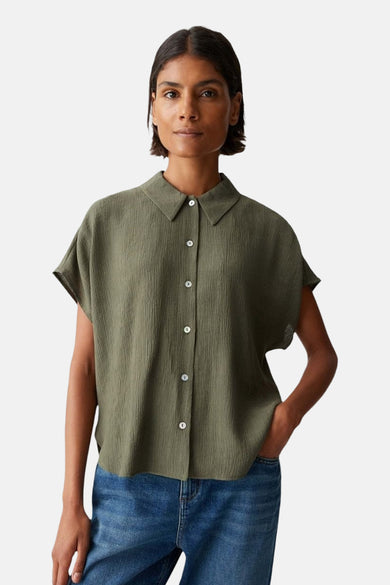 Groen hemd met korte mouwen van OPUS, met een subtiele textuur en gedragen met een blauwe jeans.
