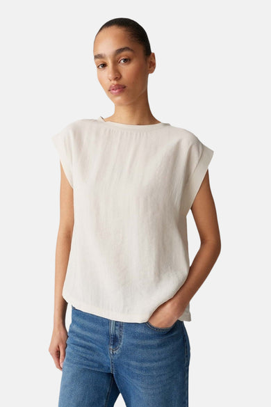 Ecru mouwloze blouse van OPUS, gecombineerd met blauwe jeans.