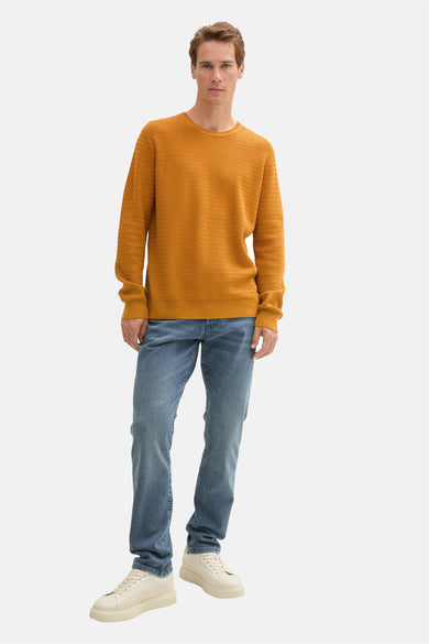 Gele trui met ronde hals van TOM TAILOR, gecombineerd met jeans en crèmekleurige sneakers.