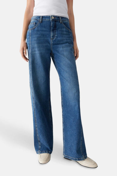 Donkerblauwe wijde jeans van OPUS, met hoge taille en beige schoenen.
