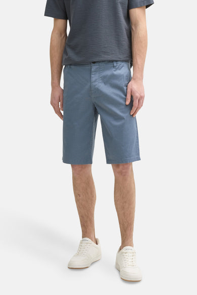 Blauwe short van TOM TAILOR, gedragen met een donkergrijs T-shirt en witte sneakers.