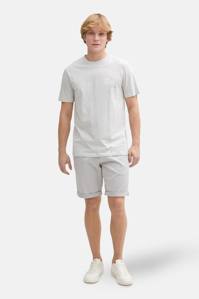 Grijze short van TOM TAILOR, met rolzoom, gecombineerd met een grijs T-shirt en witte sneakers.