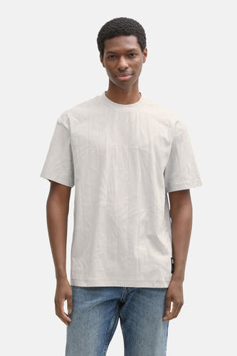 Grijs T-shirt met korte mouwen van TOM TAILOR, met een subtiel bladmotief en gedragen met blauwe jeans.
