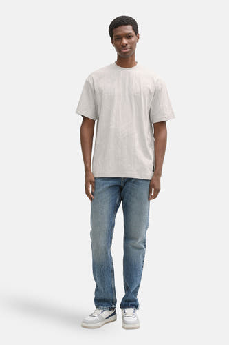 Grijs T-shirt met korte mouwen van TOM TAILOR, met een subtiel bladmotief, gecombineerd met blauwe jeans en witte sneakers.