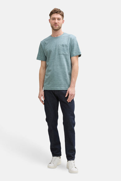 Groen T-shirt met korte mouwen van TOM TAILOR, met borstzak, gecombineerd met donkere jeans en witte sneakers.
