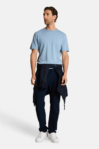 Blauw T-shirt met korte mouwen van TOM TAILOR, met een donkerblauwe trui om de taille en witte sneakers.
