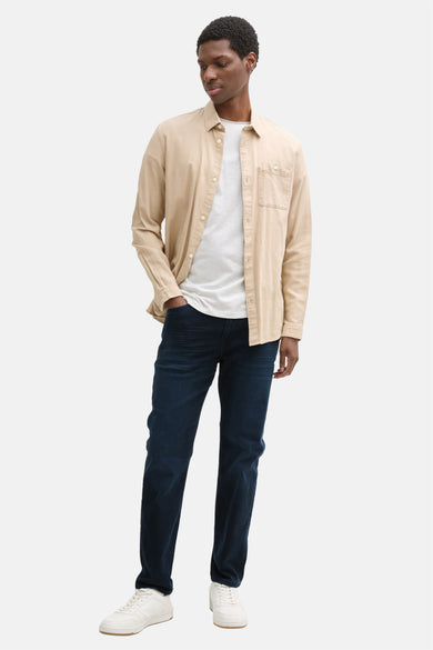 Blauwe zwarte denim tapered jeans van Tom Tailor, gecombineerd met een wit t-shirt en een beige overhemd.