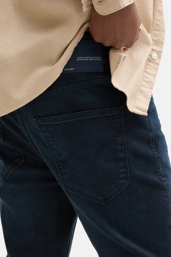 Blauwzwarte tapered jeans van TOM TAILOR, met een achterzak en een leren merklabel.