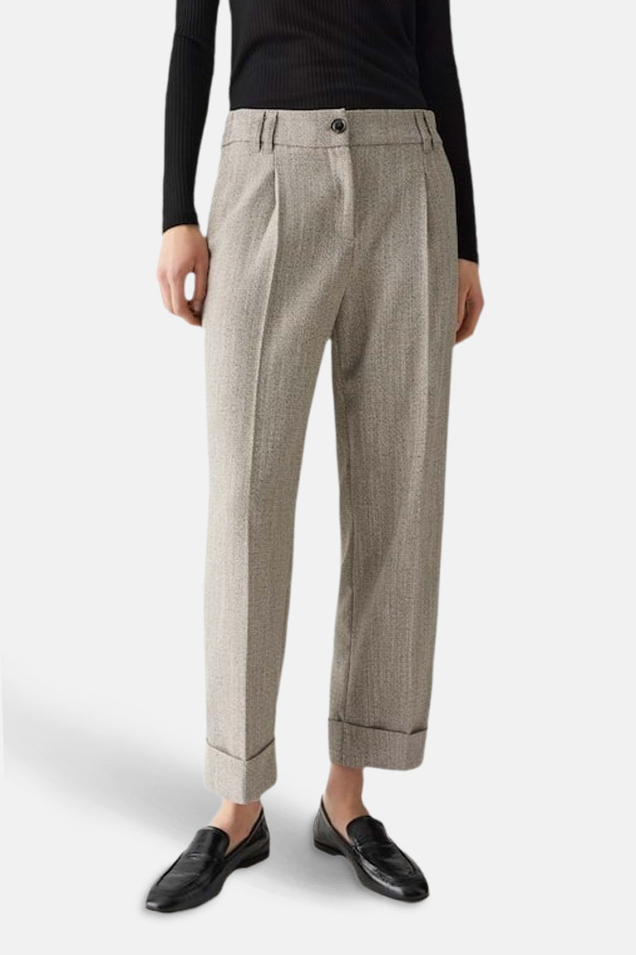 Beige kostuumbroek van OPUS met plooien en opgerolde zoom, gecombineerd met een zwarte top en zwarte loafers.