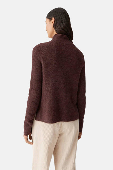 Bruine trui van OPUS, gezien vanaf de achterkant, met een hoge kraag en lange mouwen, gecombineerd met een beige corduroy broek.
