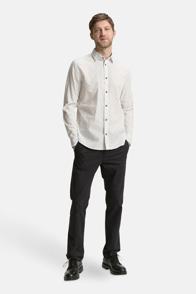 Wit overhemd met lange mouwen van TOM TAILOR, met een subtiel stippenpatroon, gecombineerd met een zwarte broek en leren schoenen.
