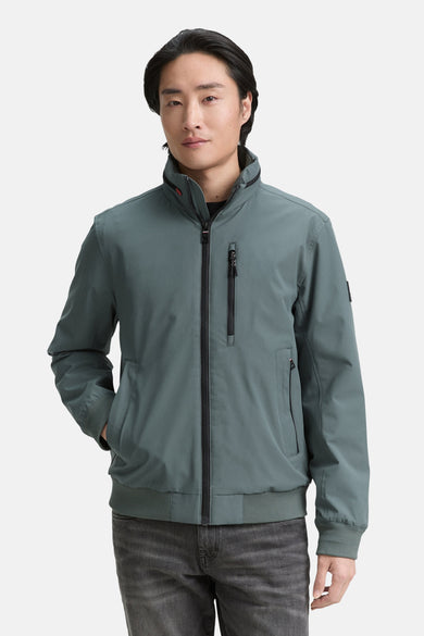 Groene korte jas van TOM TAILOR, met lange mouwen en een ritssluiting, gedragen met donkere jeans.
