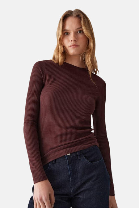 Bruine trui met ronde hals van OPUS, in ribgebreide textuur, gecombineerd met een donkere jeans.

