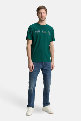 Groen T-shirt met korte mouwen van TOM TAILOR, gedragen met blauwe jeans en witte sneakers.