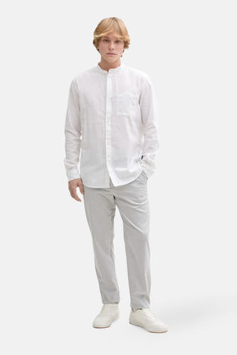 Grijze chino van TOM TAILOR, gecombineerd met een wit linnen overhemd en witte sneakers.
