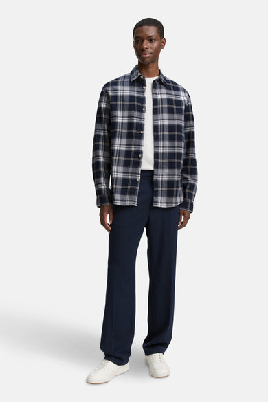 Blauw overhemd met lange mouwen van TOM TAILOR, met een ruitpatroon, gedragen over een wit T-shirt met donkerblauwe broek en witte sneakers.