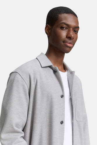 Grijs hemd van TOM TAILOR, met knoopsluiting en een borstzak, gedragen over een wit t-shirt.