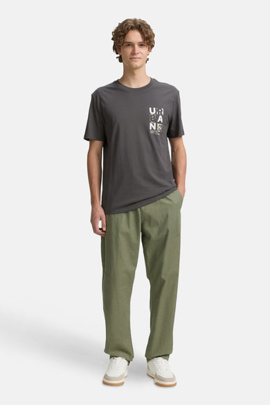 T-shirt gris à manches courtes de TOM TAILOR, avec une impression sur la poitrine, associé à des pantalons olive et des baskets blanches.