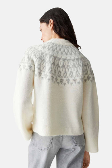 Witte trui met ronde hals van OPUS, met grijs patroon op de schouders, gecombineerd met een grijze jeans.

