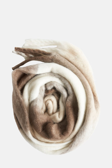 Meerkleurige wintersjaal van OPUS, opgerold in een spiraalvorm met verschillende bruine en witte tinten.