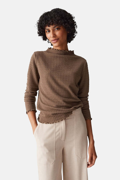 T-shirt brun à manches longues d'OPUS, avec une texture froissée et un col plié, associé à des pantalons crème.