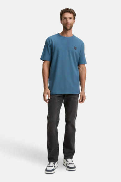 Blauw T-shirt met korte mouwen van TOM TAILOR, gedragen met zwarte jeans en witte sneakers.