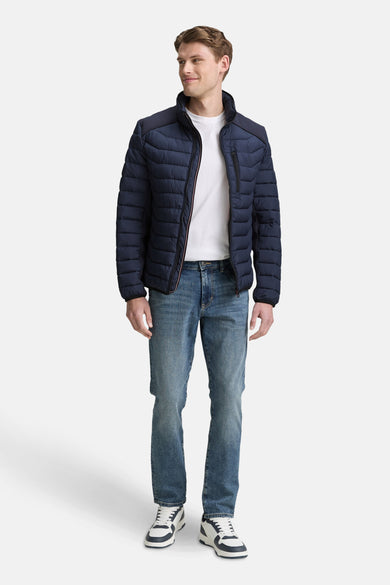 Manteau court bleu de TOM TAILOR, avec fermeture éclair, associé à des jeans et des baskets blanches.