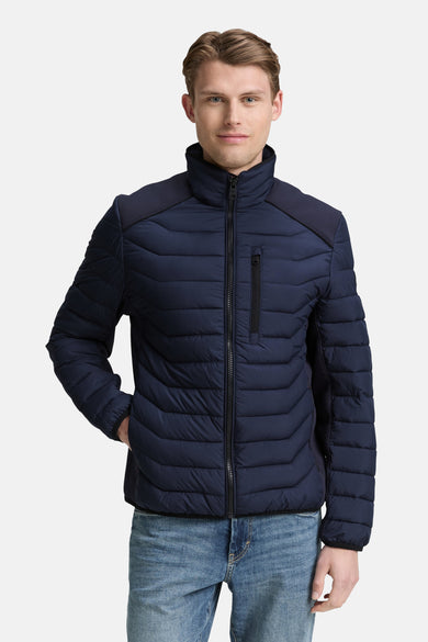 Manteau court bleu de Tom Tailor, avec fermeture éclair et poches, porté sur un jean.