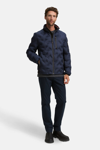 Korte blauwe jas van TOM TAILOR, met doorgestikt patroon, gecombineerd met donkere broek en zwarte schoenen.