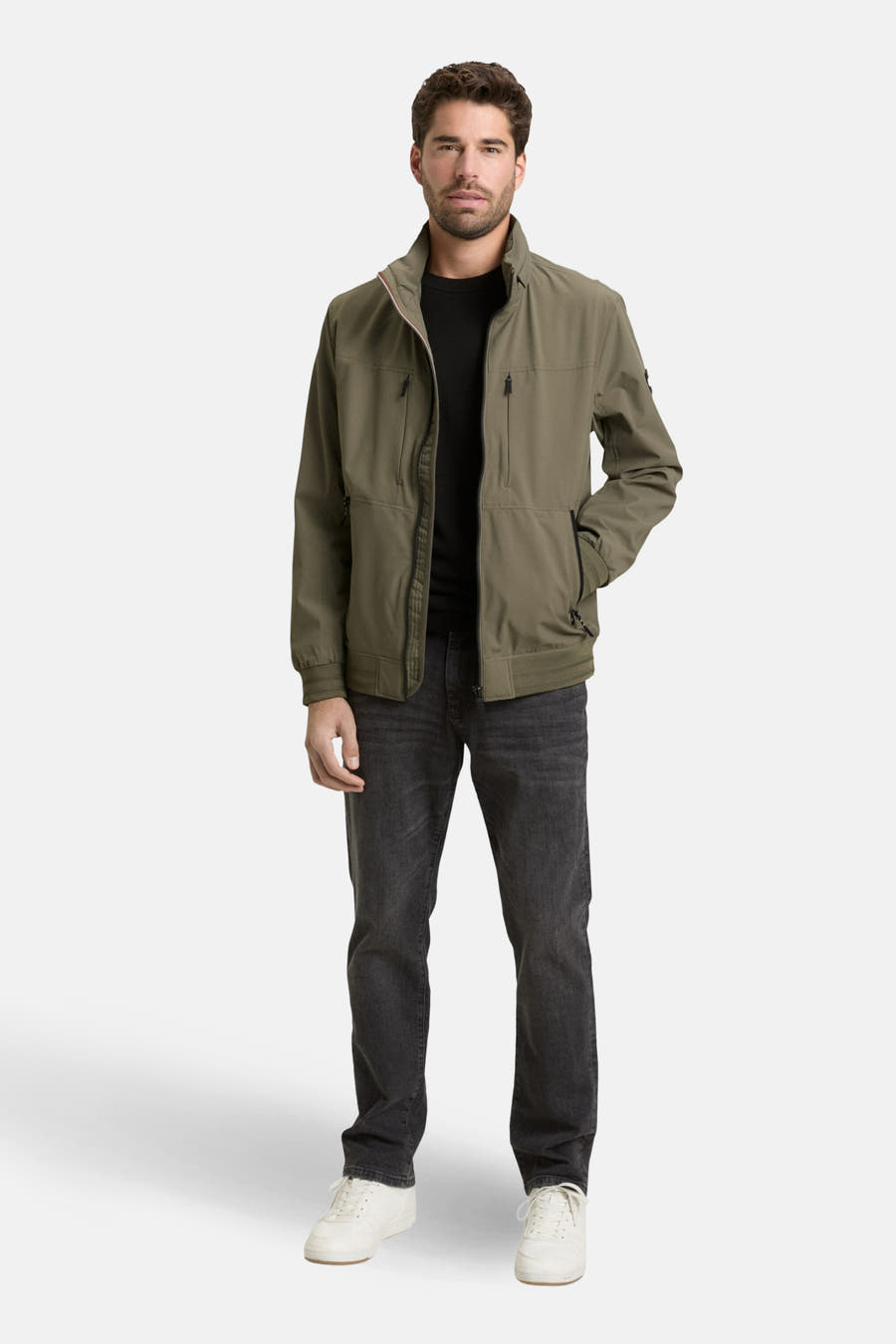 Groene korte jas van TOM TAILOR, met een zwarte T-shirt en donkere jeans.