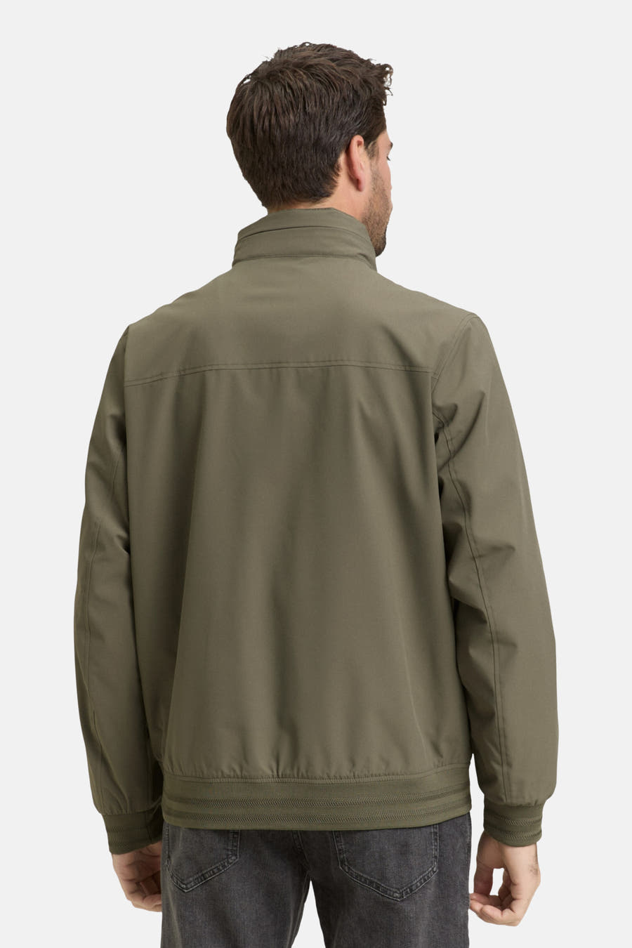 Groene korte jas van TOM TAILOR, rugaanzicht, met hoge kraag en grijze jeans.
